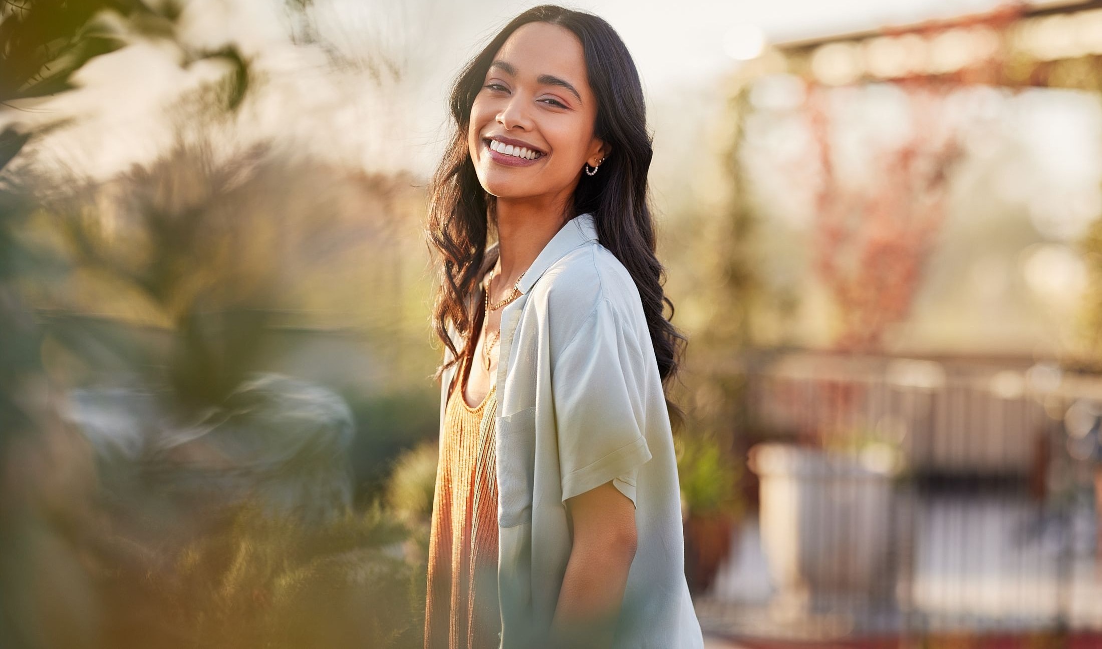Alpharetta Women's Wellness model in nature, soft sunlight background.